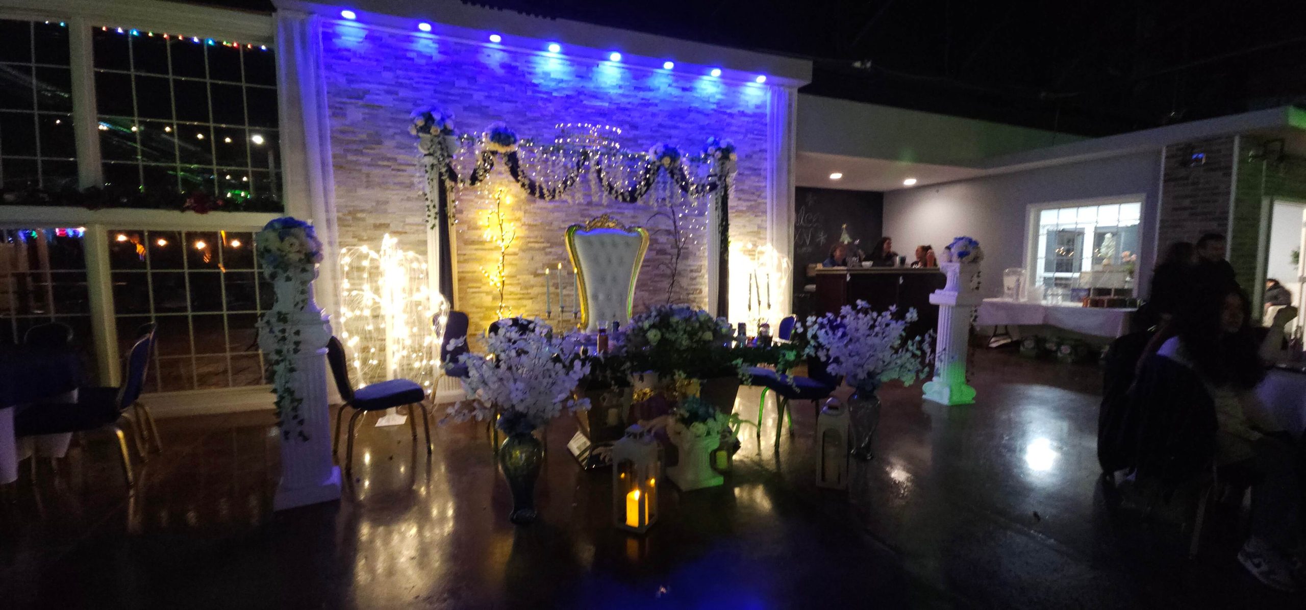 elegant flowers and lighting with faux roman marble all around a large regal chair