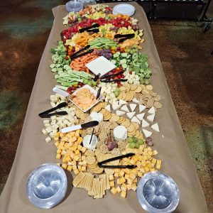 table covered in an array of finger foods like cheese crackers and veggies